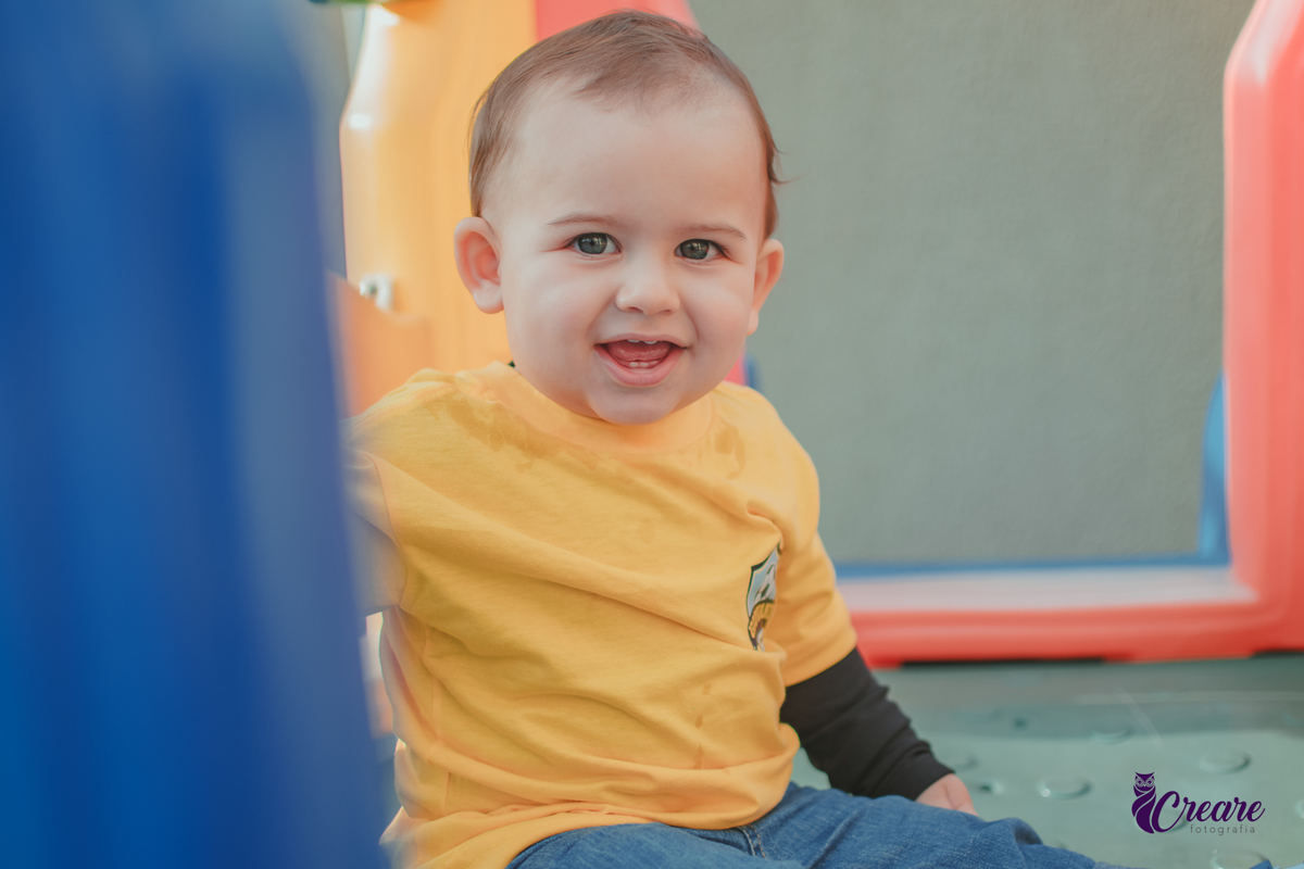 Um bebê sorrindo e brincando durante seu aniversário de 1 ano.