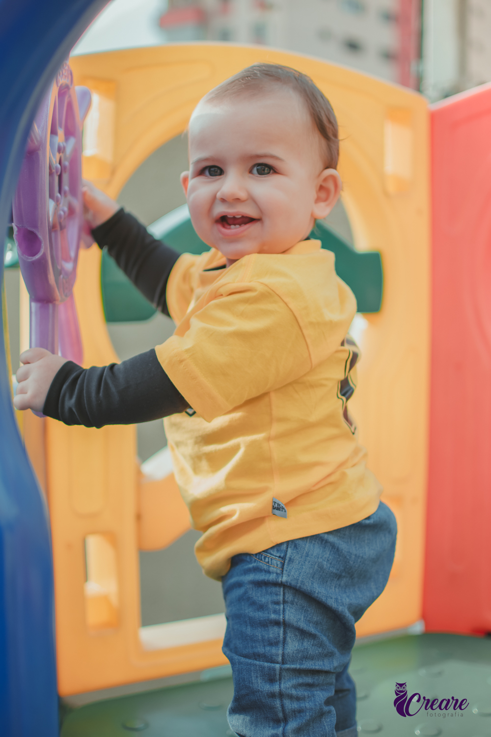 Um bebê sorrindo e brincando durante seu aniversário de 1 ano.