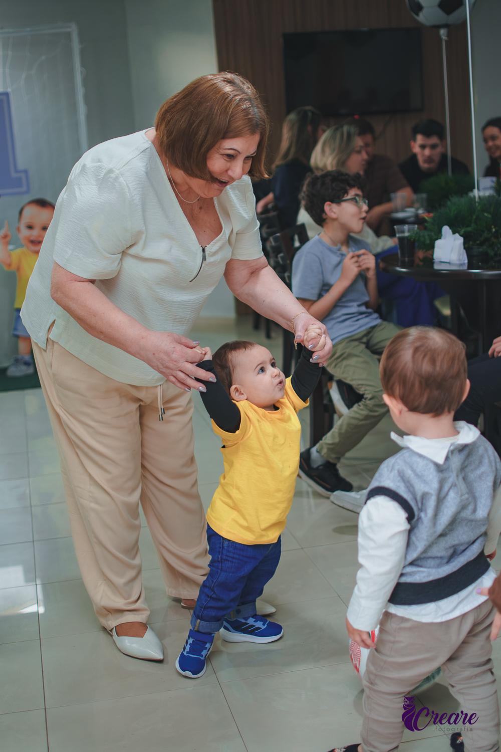 Uma mulher andando de mão dadas com um bebê, durante aniversário de 1 ano.