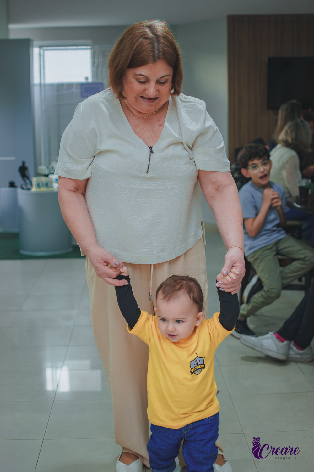 Uma mulher andando de mão dadas com um bebê, durante aniversário de 1 ano.