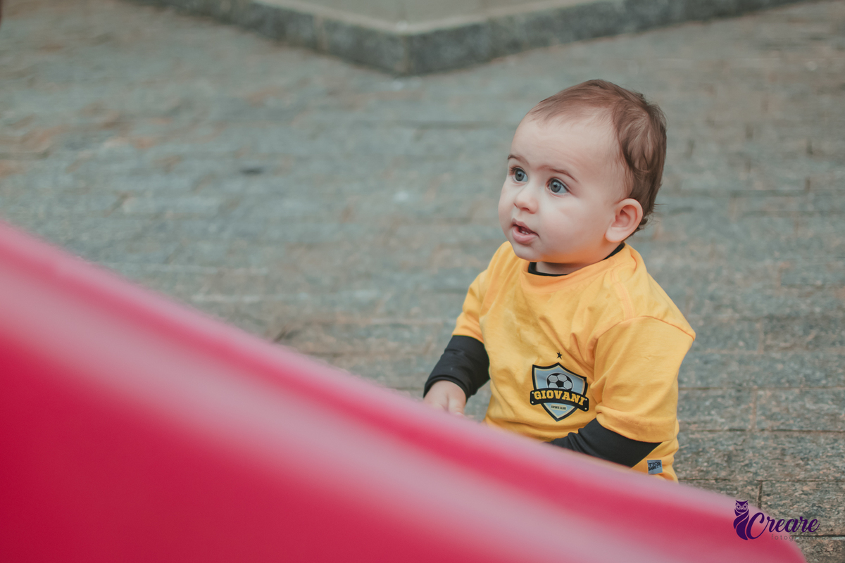 Um bebê brincando no parquinho durante sua festa de aniversário de 1 ano em Santo André.