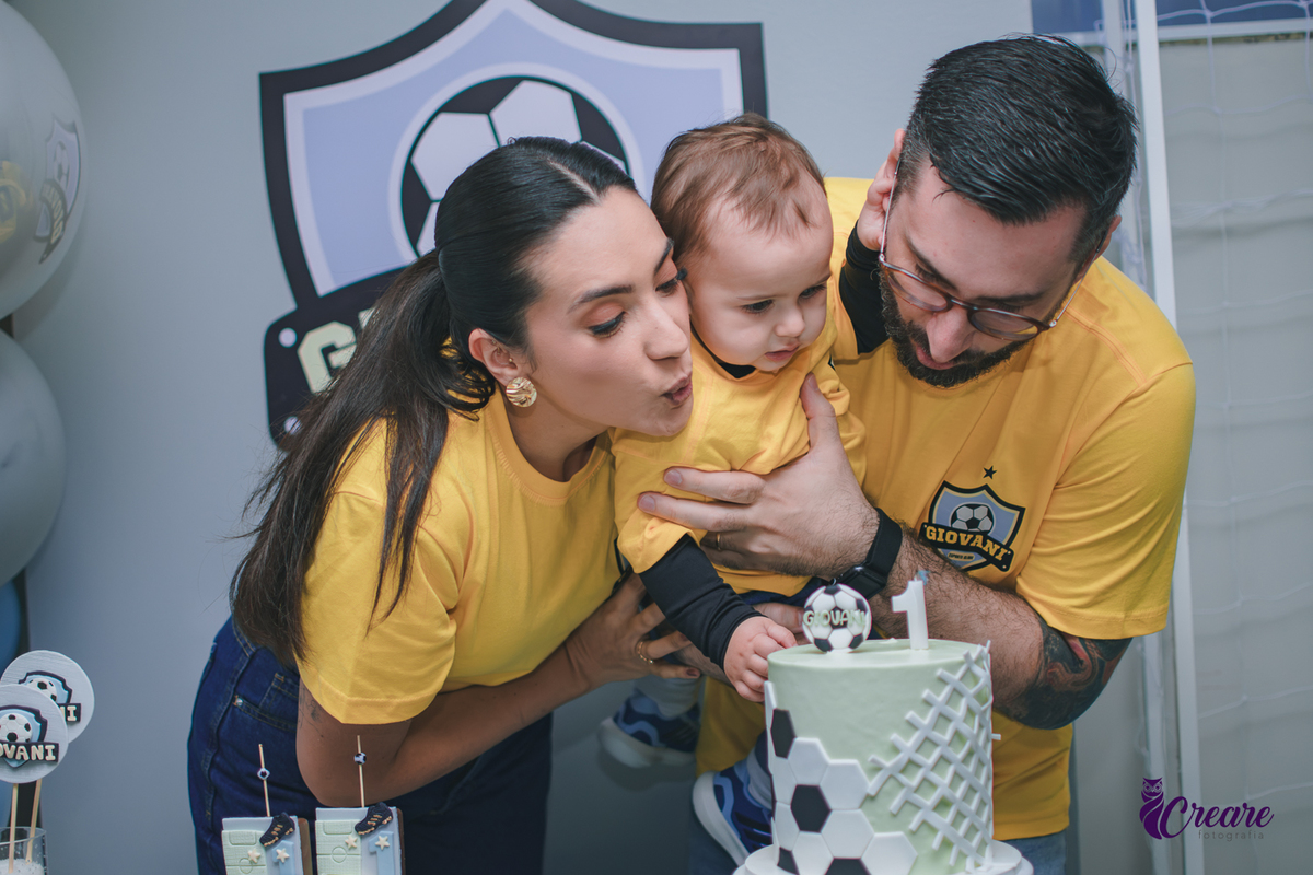 Família soprando a vela de aniversário parabéns, durante a festa de aniversário, reunida ao redor da mesa de decoração em um momento de celebração.