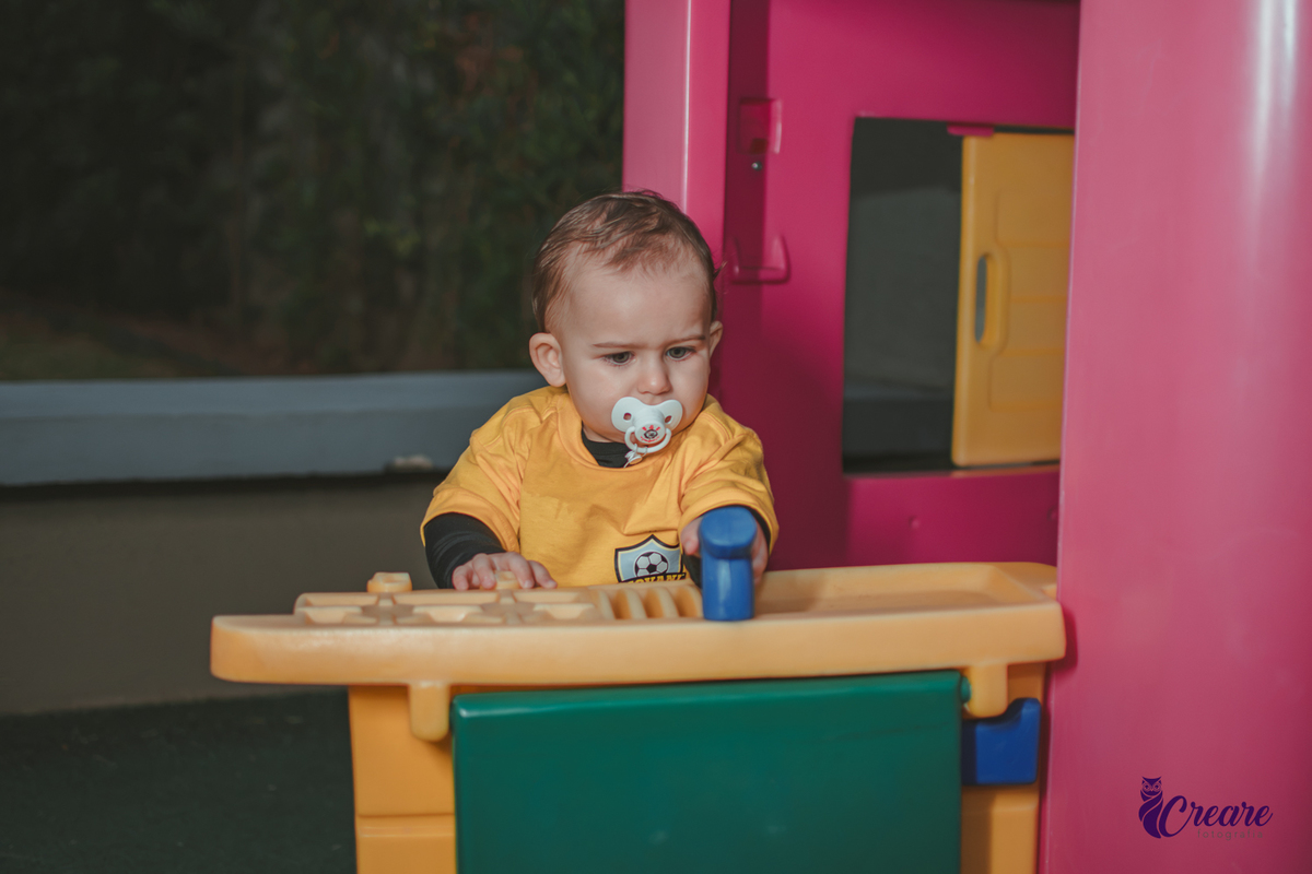 Um bebê brincando no parquinho durante sua festa de aniversário de 1 ano em Santo André.