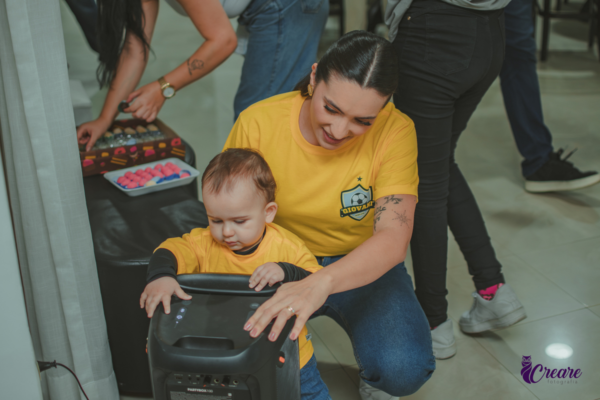 Bebê e sua mãe brincando com caixa de som, durante sua festa de aniversário de 1 ano em Santo André.