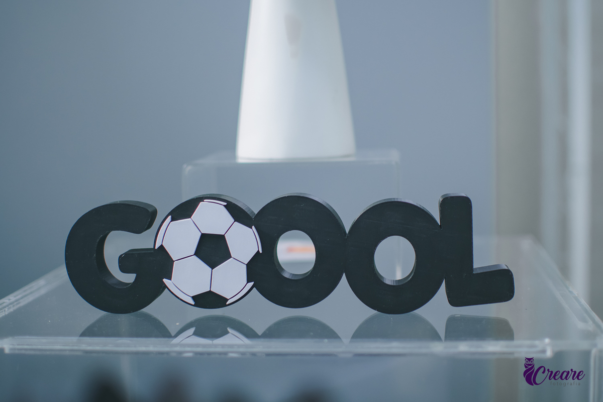 Decoração de aniversário de 1 ano escirto Goool em preto e uma das letas O formada por uma bola de futebol.