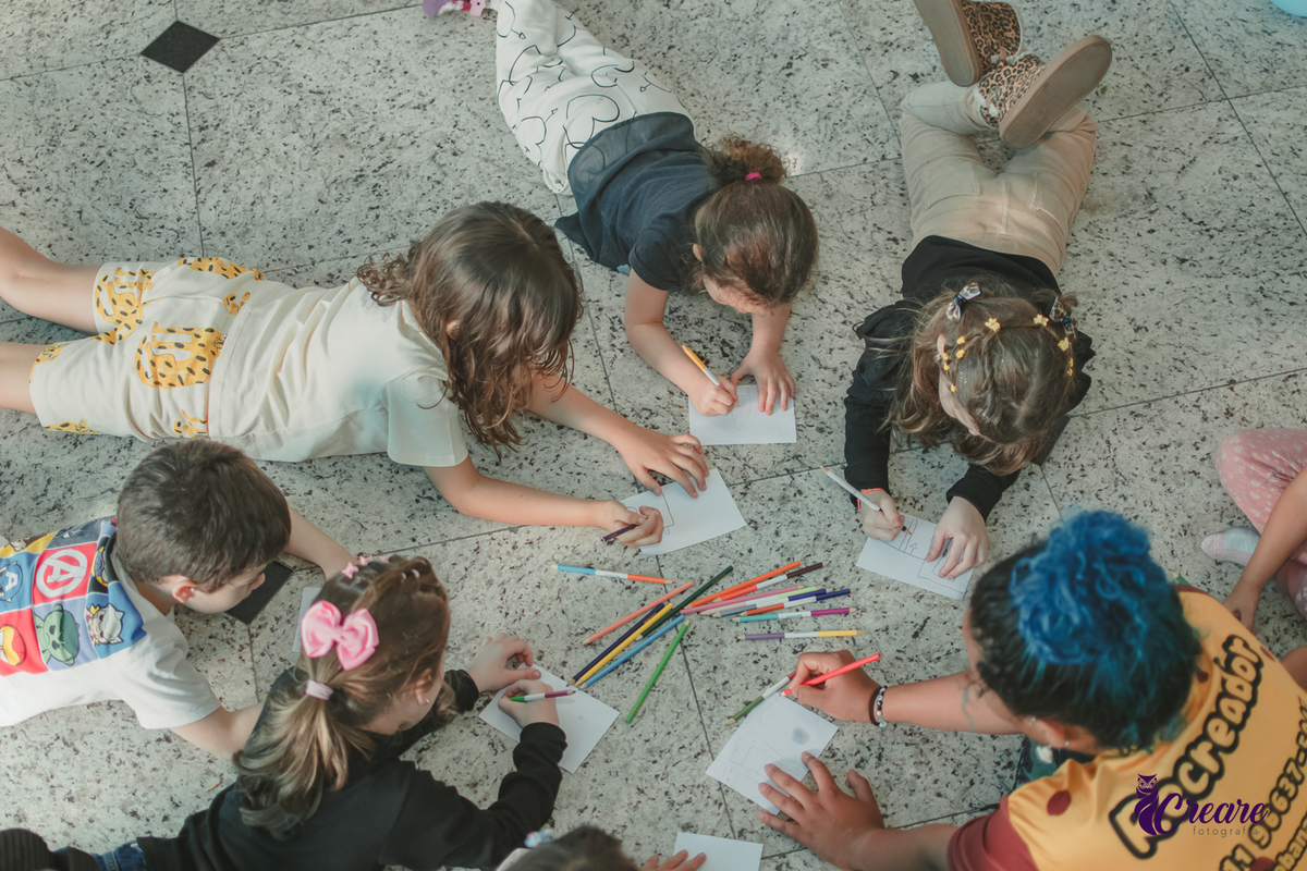 detalhes de crianças desenhando no chão, durante festa de aniversário infantil em casa.