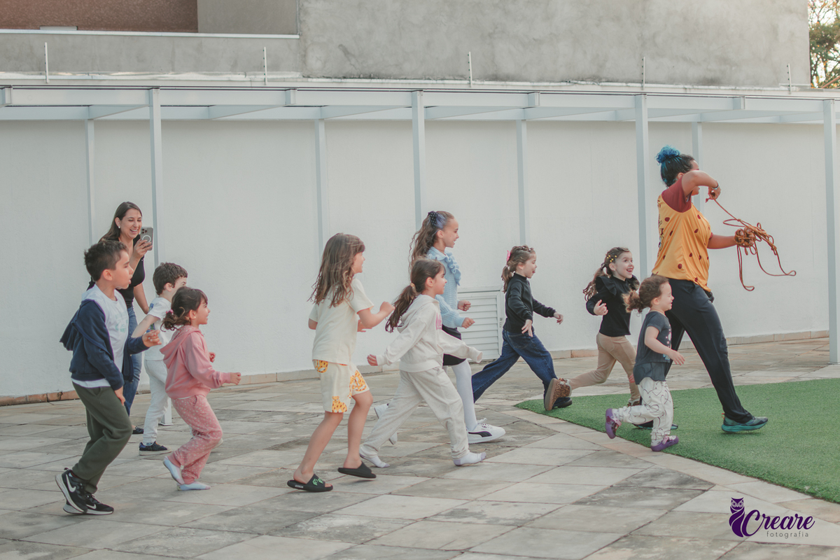 Crianças brincando na área de lazer de um condomínio, durante festa de aniversário infantil.