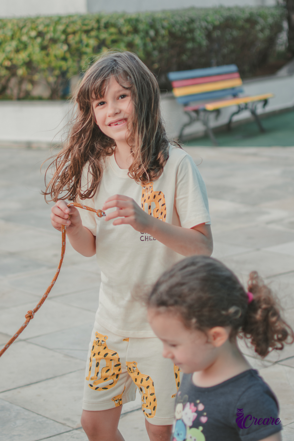 Um menino sorrindo e segurando uma corda, durante brincadeira de festa infantil.