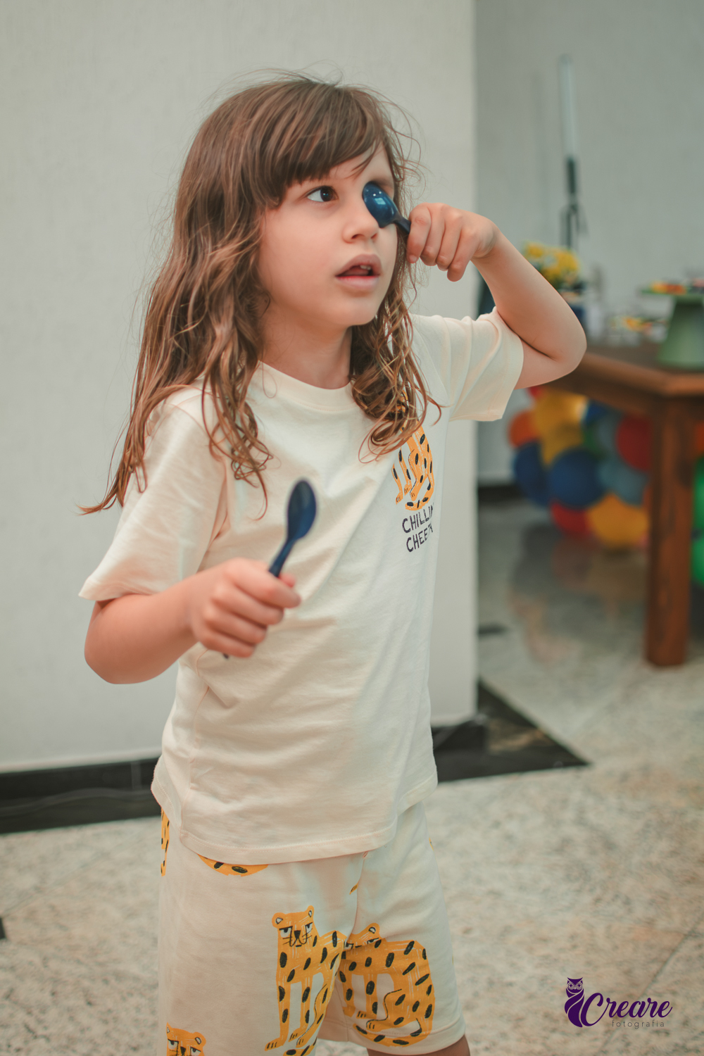 Brincandeiras musicais, feita com colheres, durante festa de aniversário infantil.