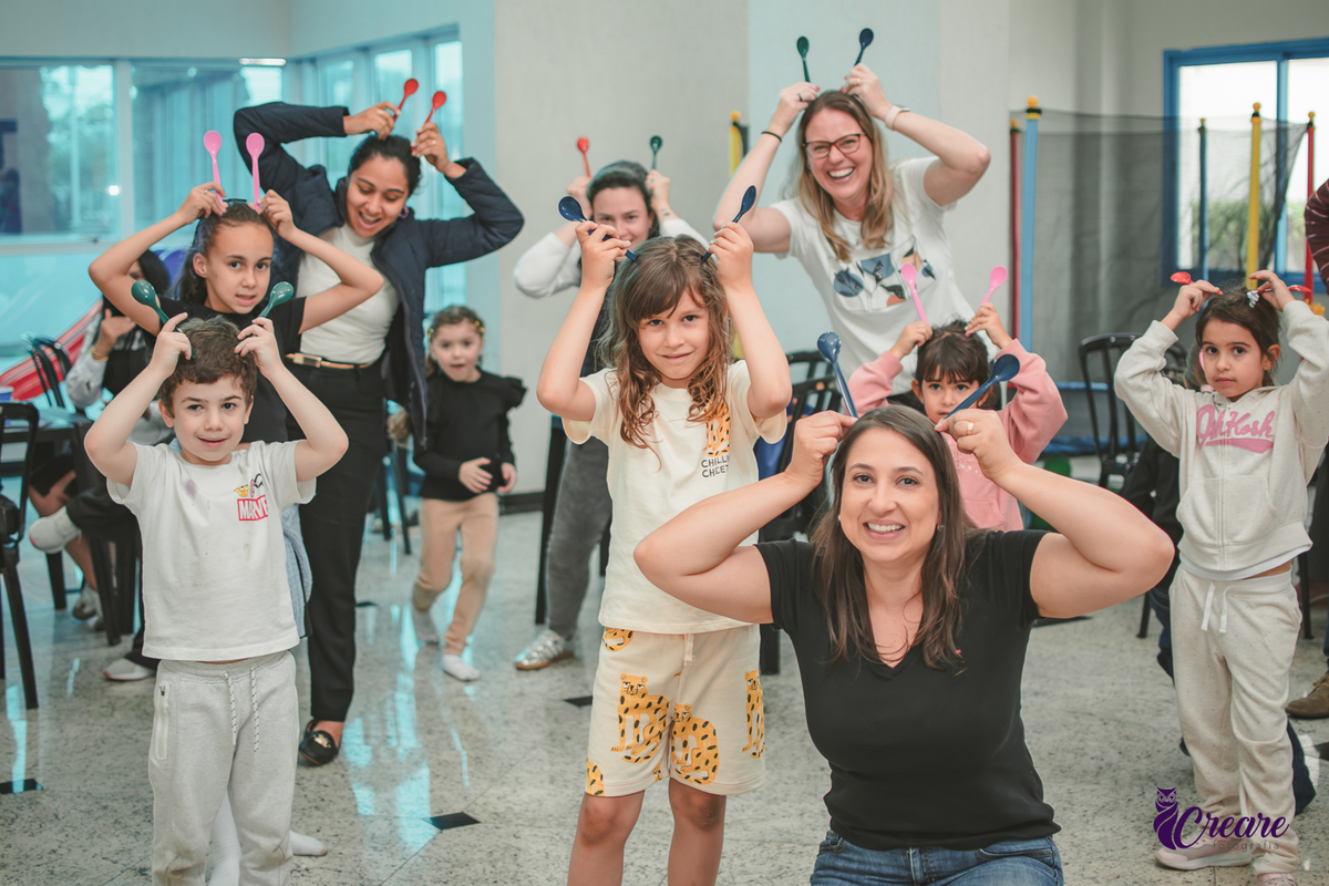 Brincandeiras musicais, feita com colheres, durante festa de aniversário infantil.