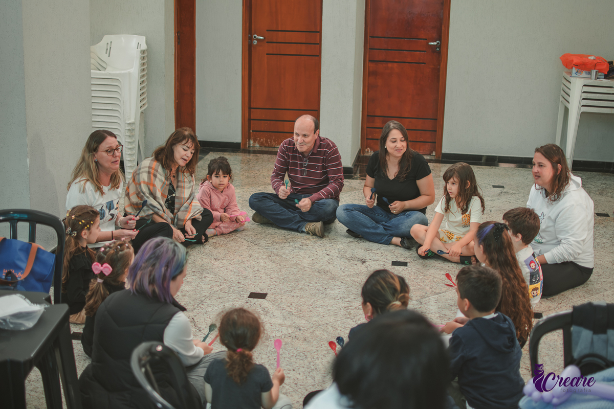 Brincandeiras musicais, feita com colheres, durante festa de aniversário infantil.