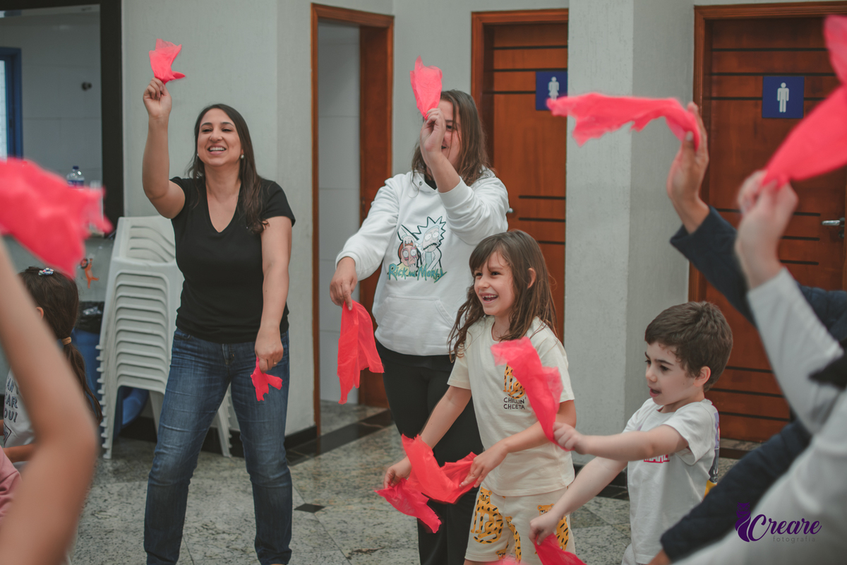 Brincadeira musical com tecidos vermelhos, realizado durante festa de aniversário infantil em casa.