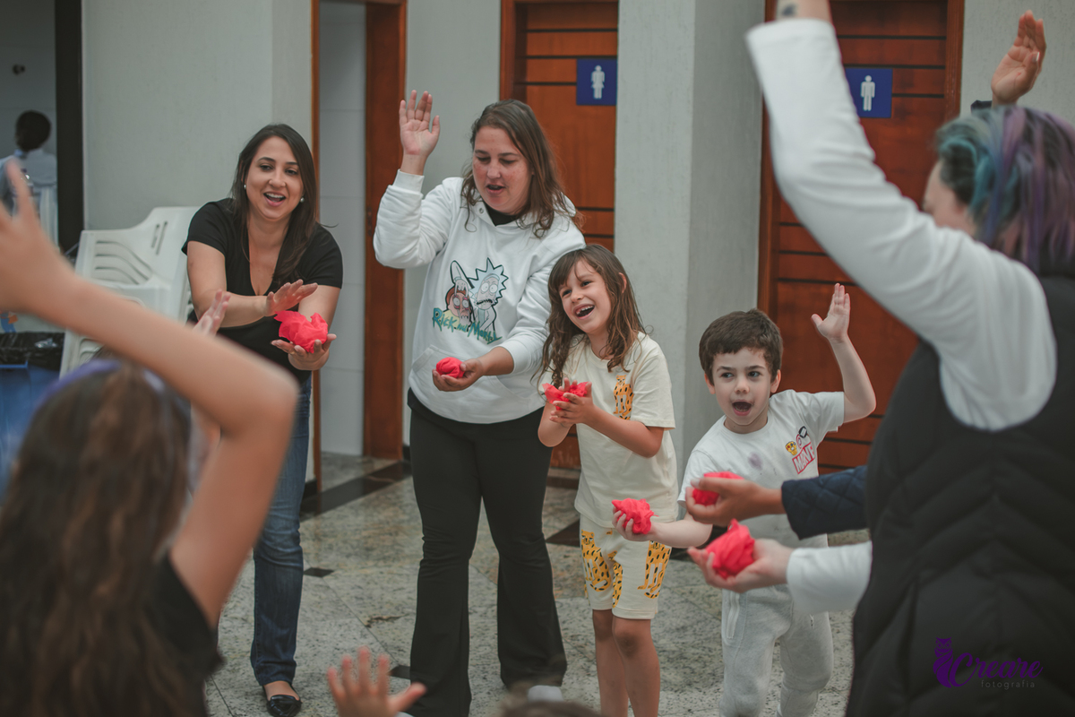 Brincadeira musical com tecidos vermelhos, realizado durante festa de aniversário infantil em casa.