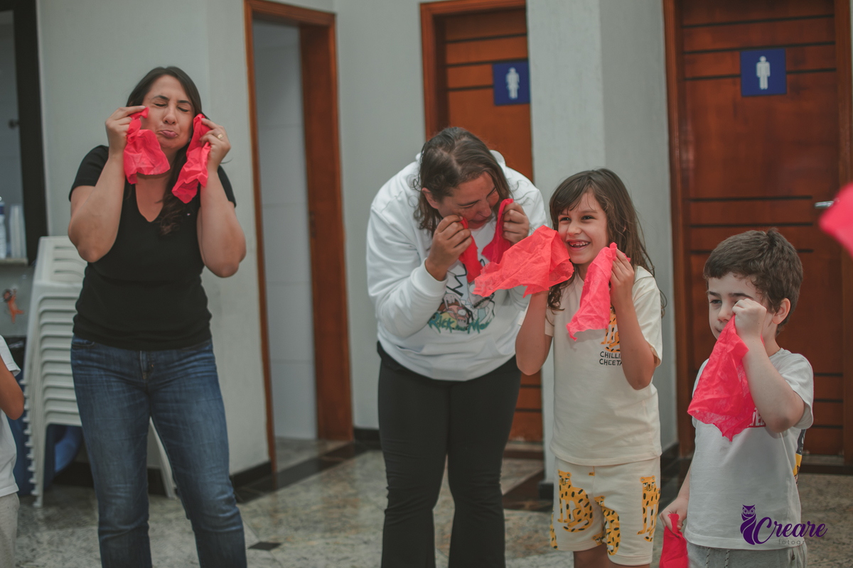 Brincadeira musical com tecidos vermelhos, realizado durante festa de aniversário infantil em casa.