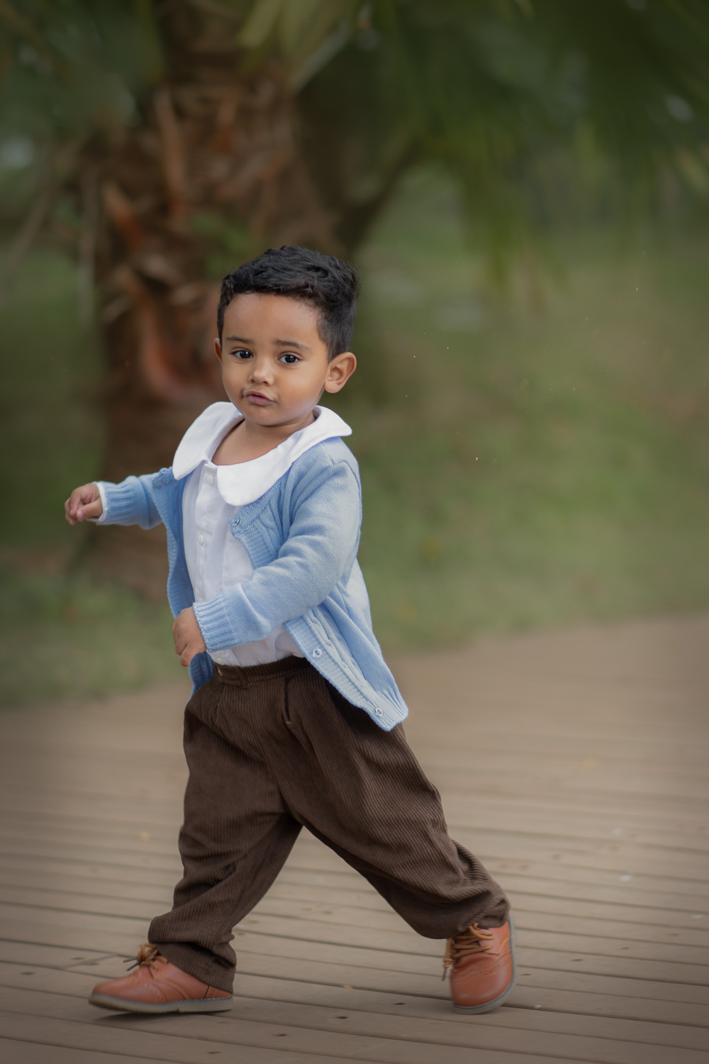 Um menino brincando de correr, no parque Luis Carlos Grecco, durante seu ensaio fotográfico de 2 anos.