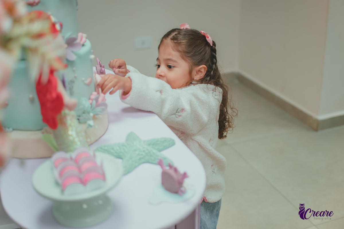Uma criança observando a decoração de sua festa de aniversário de 3 anos.