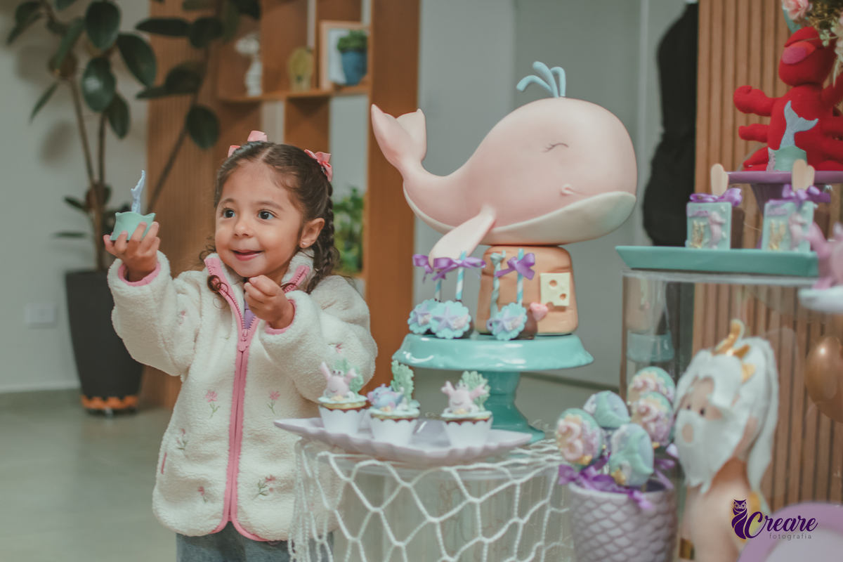 Uma criança observando a decoração de sua festa de aniversário de 3 anos.