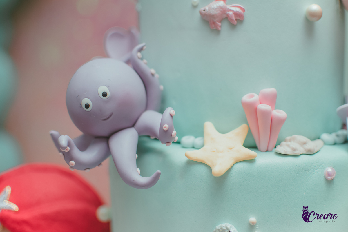 Detalhes de uma polvo roxo em um bolo de aniversário com tema A Pequena Sereia.