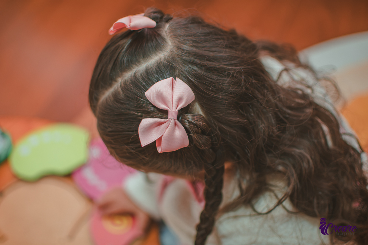 Detalhes dos lacinhos no cabelo de uma criança.