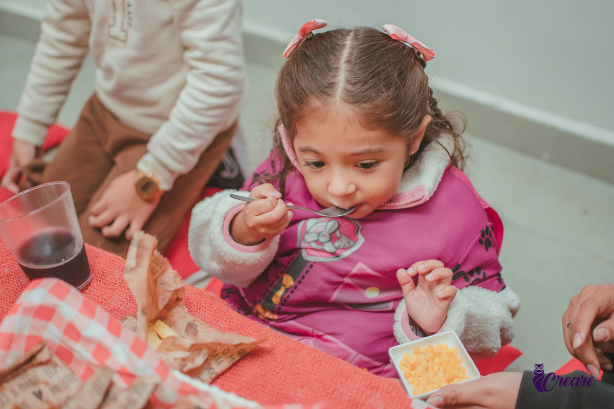 Uma crianças, na hora do lanchinho durante sua festa de aniversário de 3 anos.