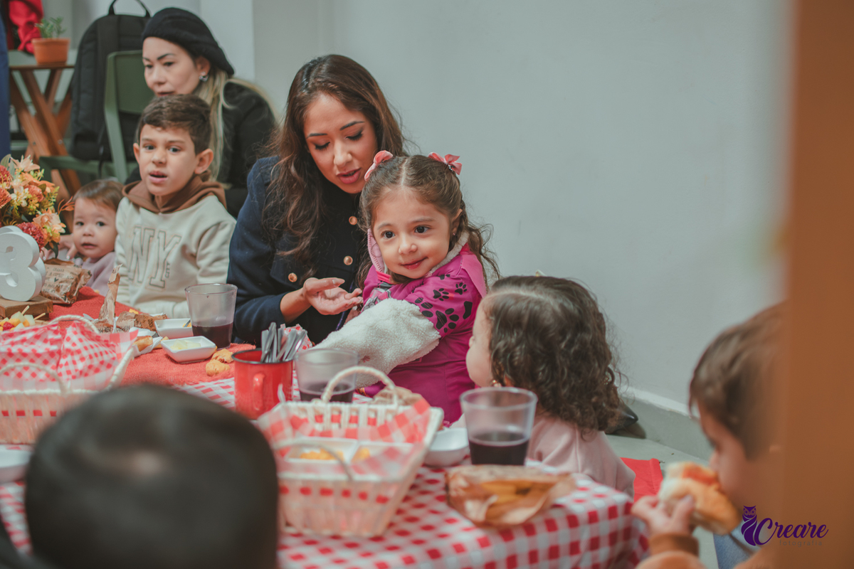 Uma crianças, na hora do lanchinho durante sua festa de aniversário de 3 anos.