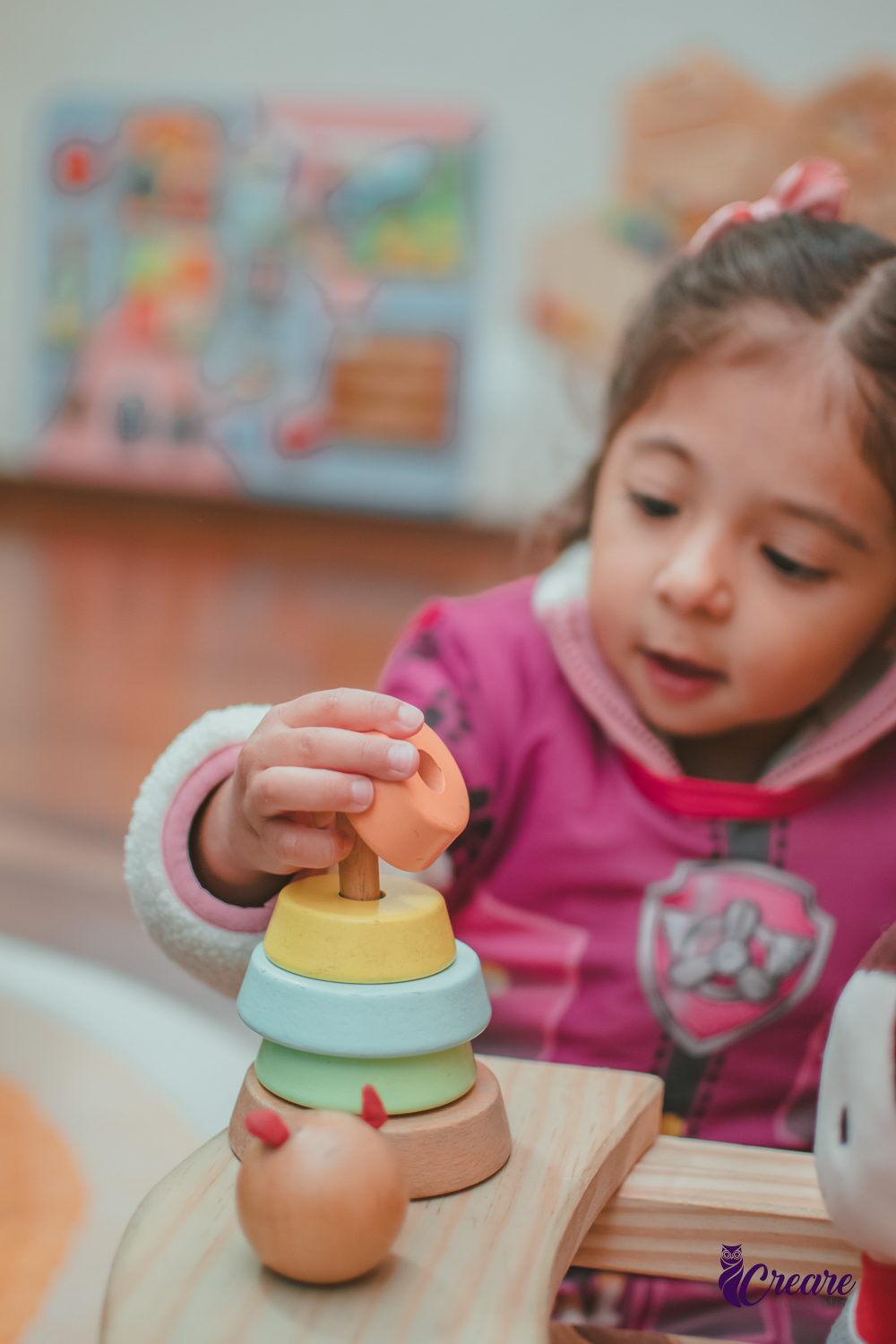 Uma criança brincando com um brinquedo sensorial de madeira, durante sua festa de aniversário.
