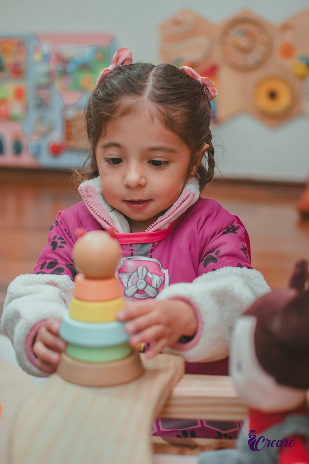 Uma criança brincando com um brinquedo sensorial de madeira, durante sua festa de aniversário.