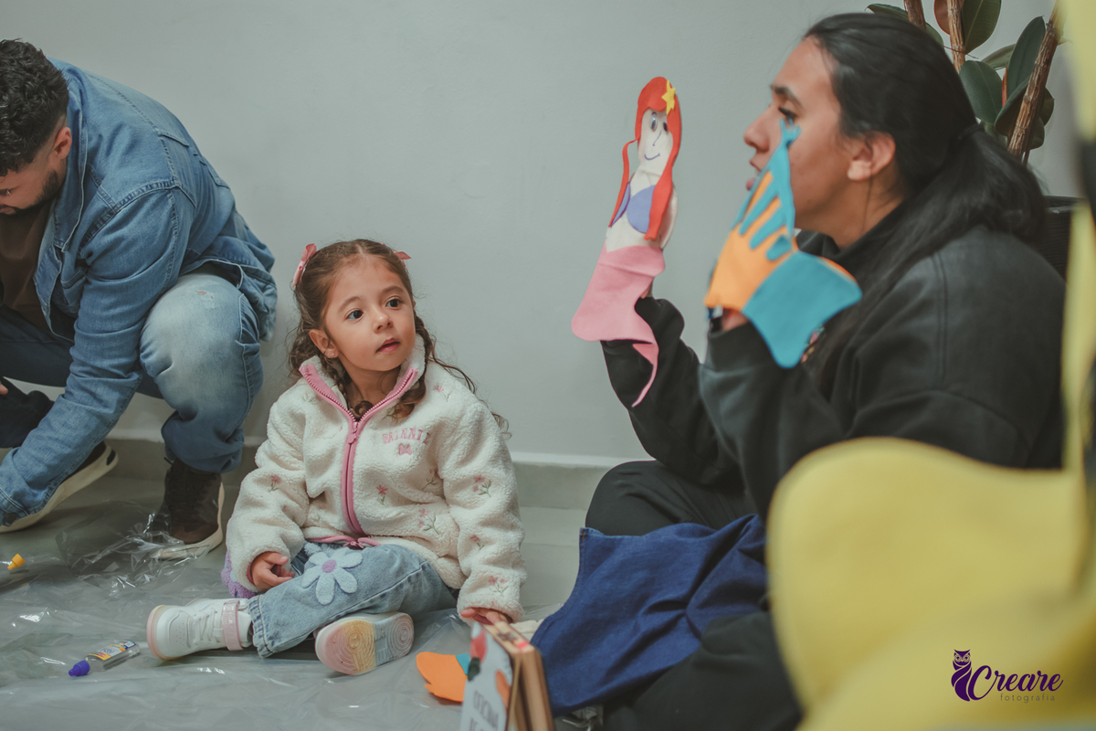 Uma Criança prestando atenção na atividade de produzir fantoches, durante festa de aniversário infantil.