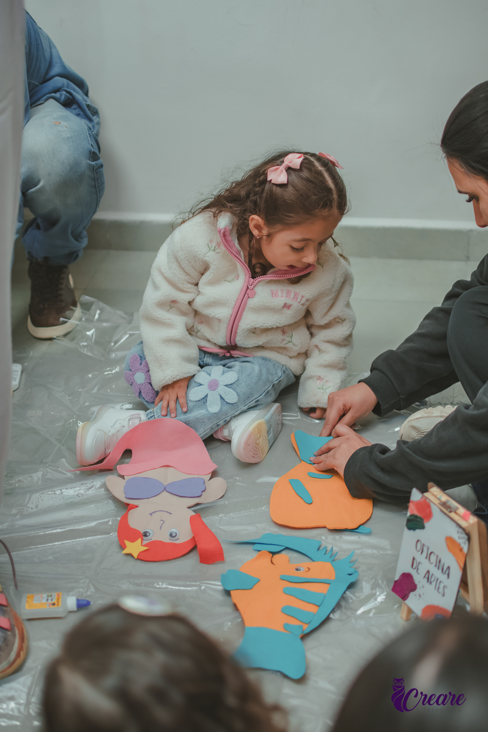 Uma Criança prestando atenção na atividade de produzir fantoches, durante festa de aniversário infantil.
