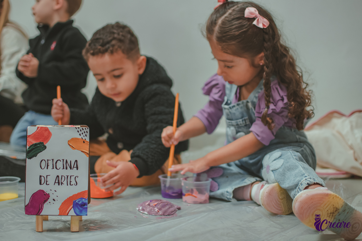Crianças fazendo atividade de pintar gesso, durante festa de aniversário infantil.