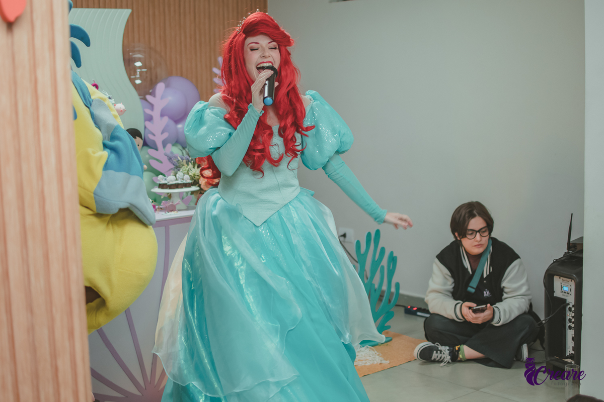 Personagem Ariel, cantando durante festa de aniversário