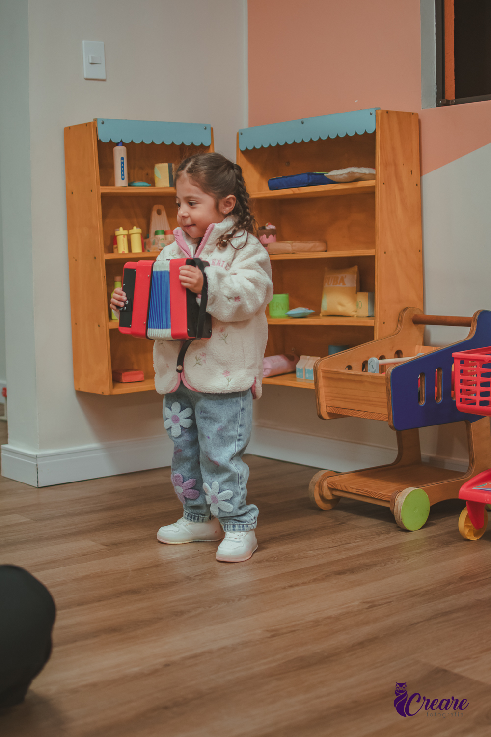 Uma criança brincando com uma sanfona de brinquedo durante sua festa de aniversário.