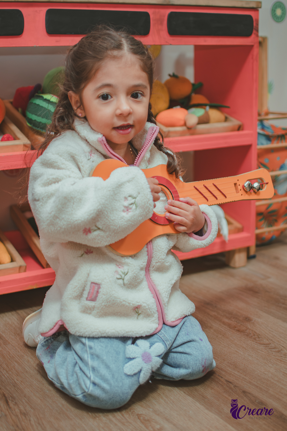 Uma criança brincando com um violão de brinquedo durante sua festa de aniversário.