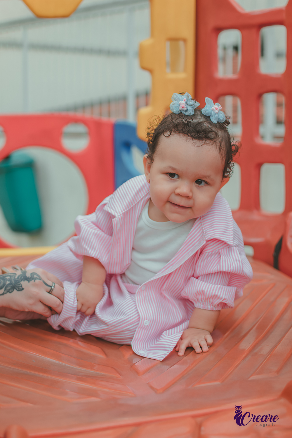 Uma bebê de 1 ano, brincando no parquinho do condomínio, durante sua festa de aniversário em casa.