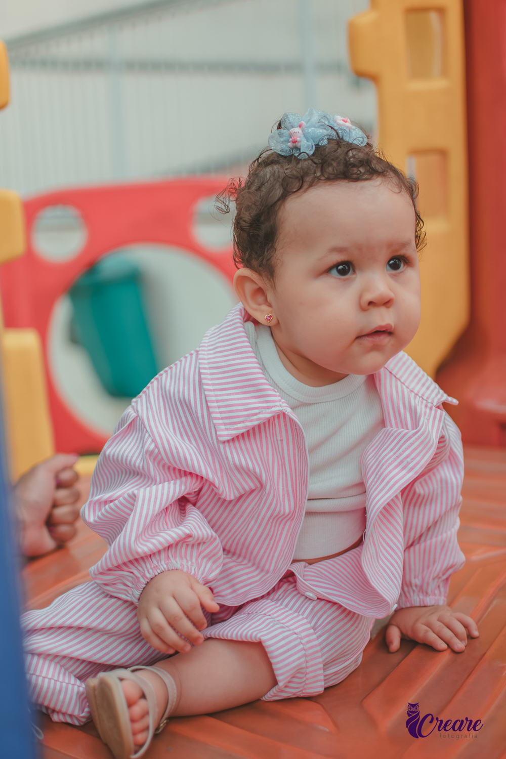 Uma bebê de 1 ano, brincando no parquinho do condomínio, durante sua festa de aniversário em casa.