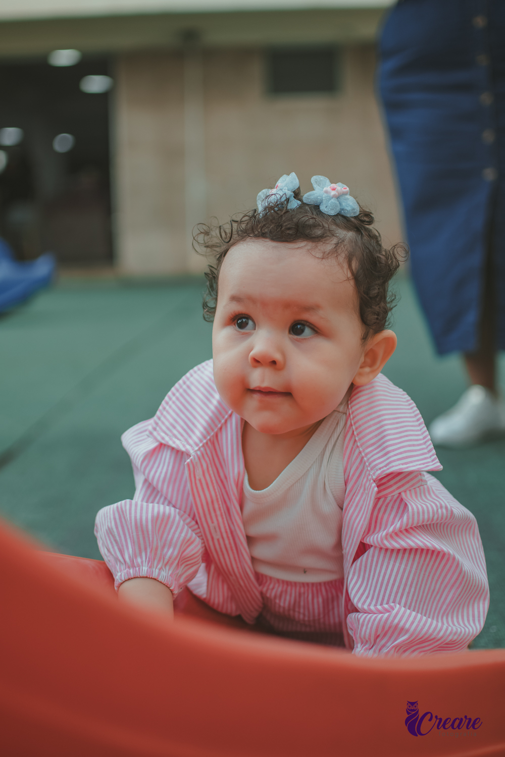 Uma bebê de 1 ano, brincando no parquinho do condomínio, durante sua festa de aniversário em casa.