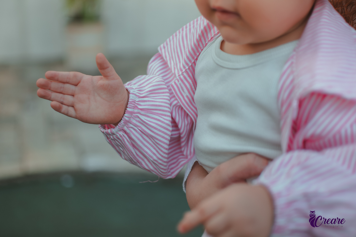 A  mão de uma bebê que estava brincando durante sua festa de aniversário de 1 ano.