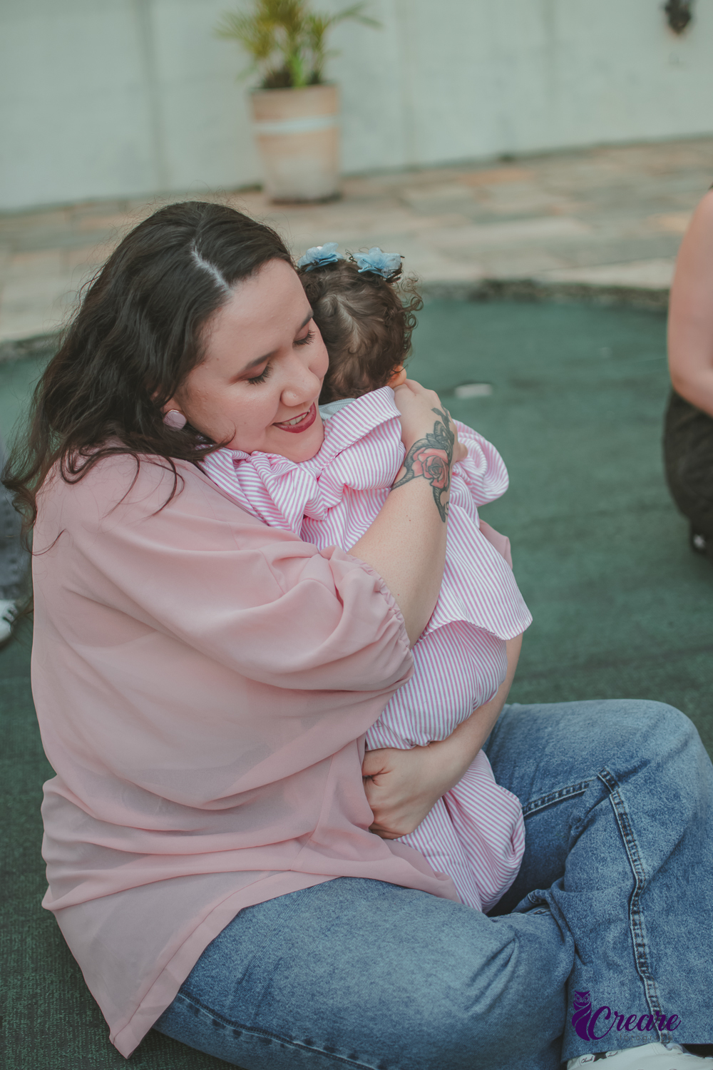 Uma mãe abraçando sua bebê, durante festa de aniversário de 1 ano em casa.