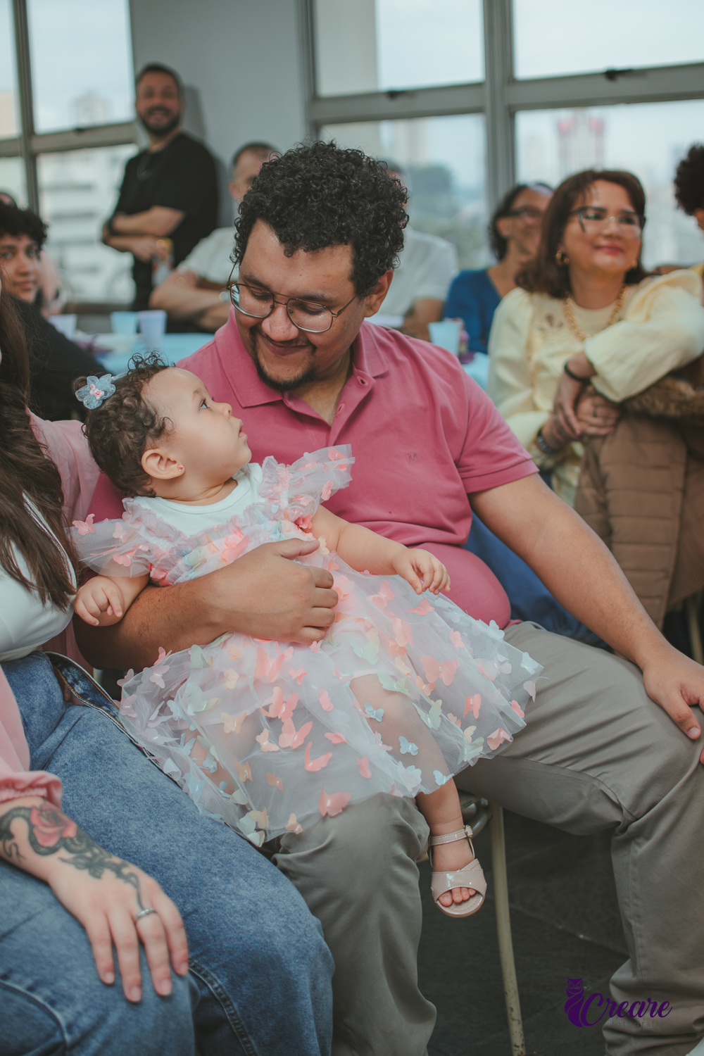 Um pai emocionado assistindo a restrospectiva, durante festa de aniversário de 1 ano em casa.