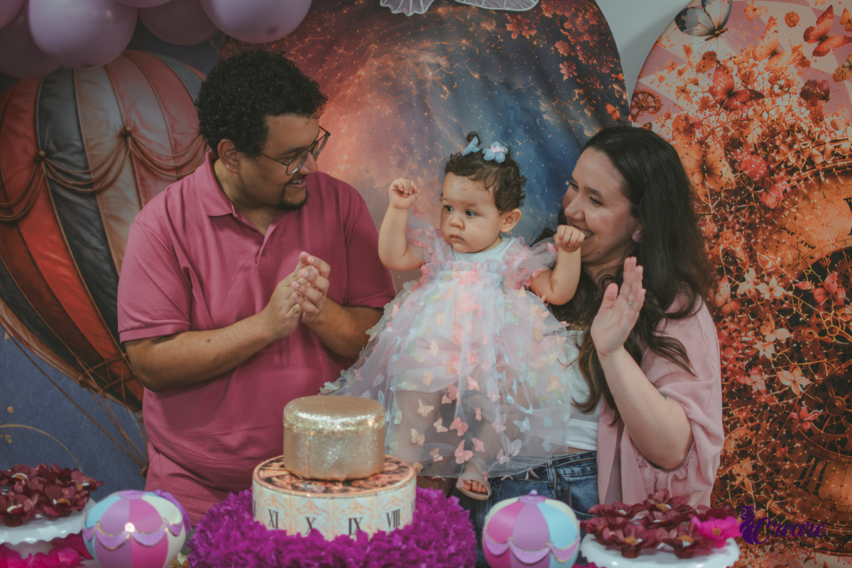 Um casal cantando parabéns, durante festa de aniversário de 1 ano em casa.