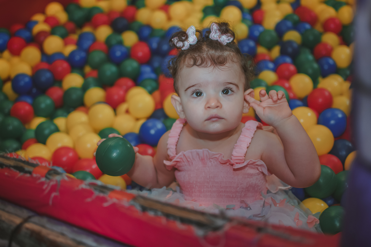 Uma bebê de um ano brincando na piscina de bolinhas durante sua festa de aniversário de 1 anoem Santo André.