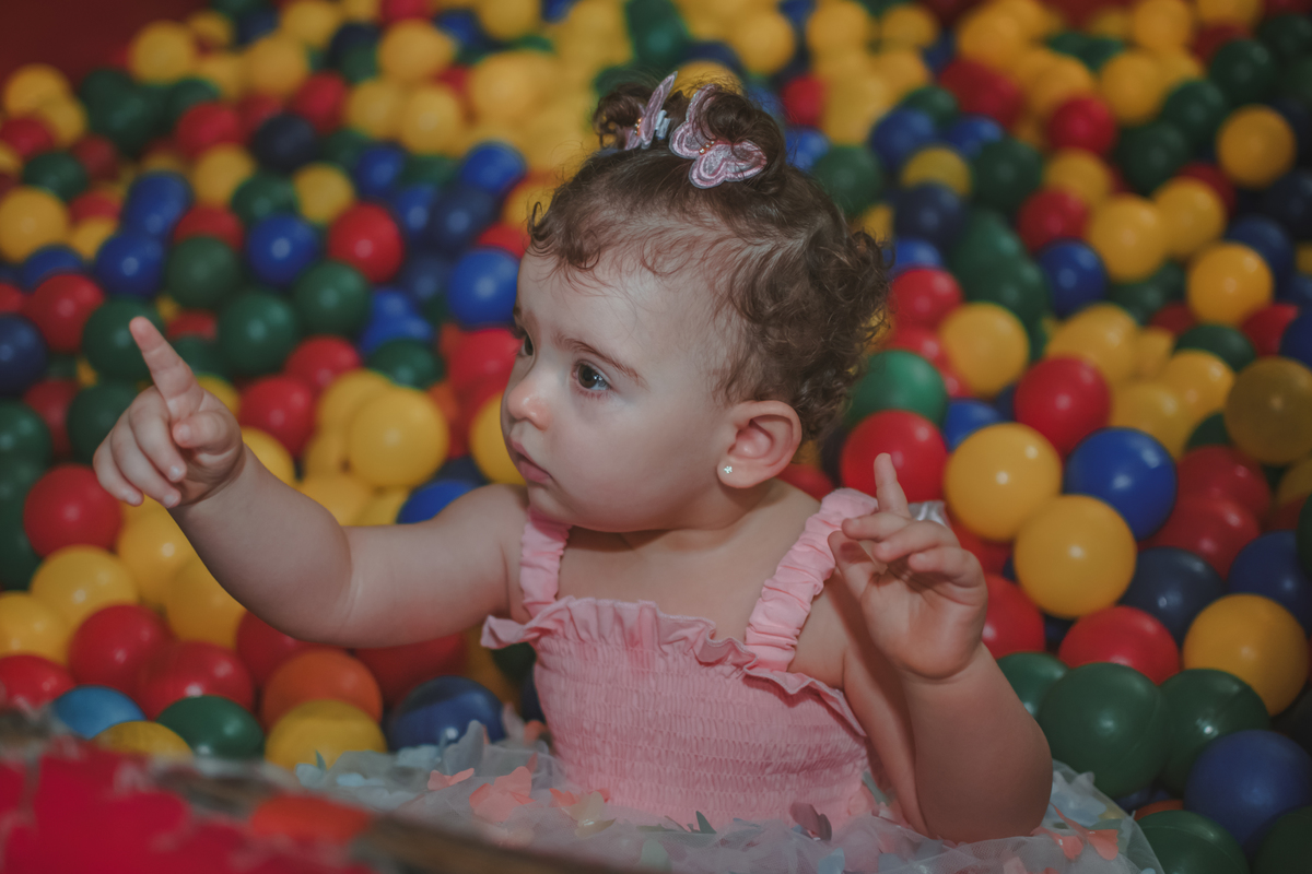 Uma bebê de um ano brincando na piscina de bolinhas durante sua festa de aniversário de 1 anoem Santo André.