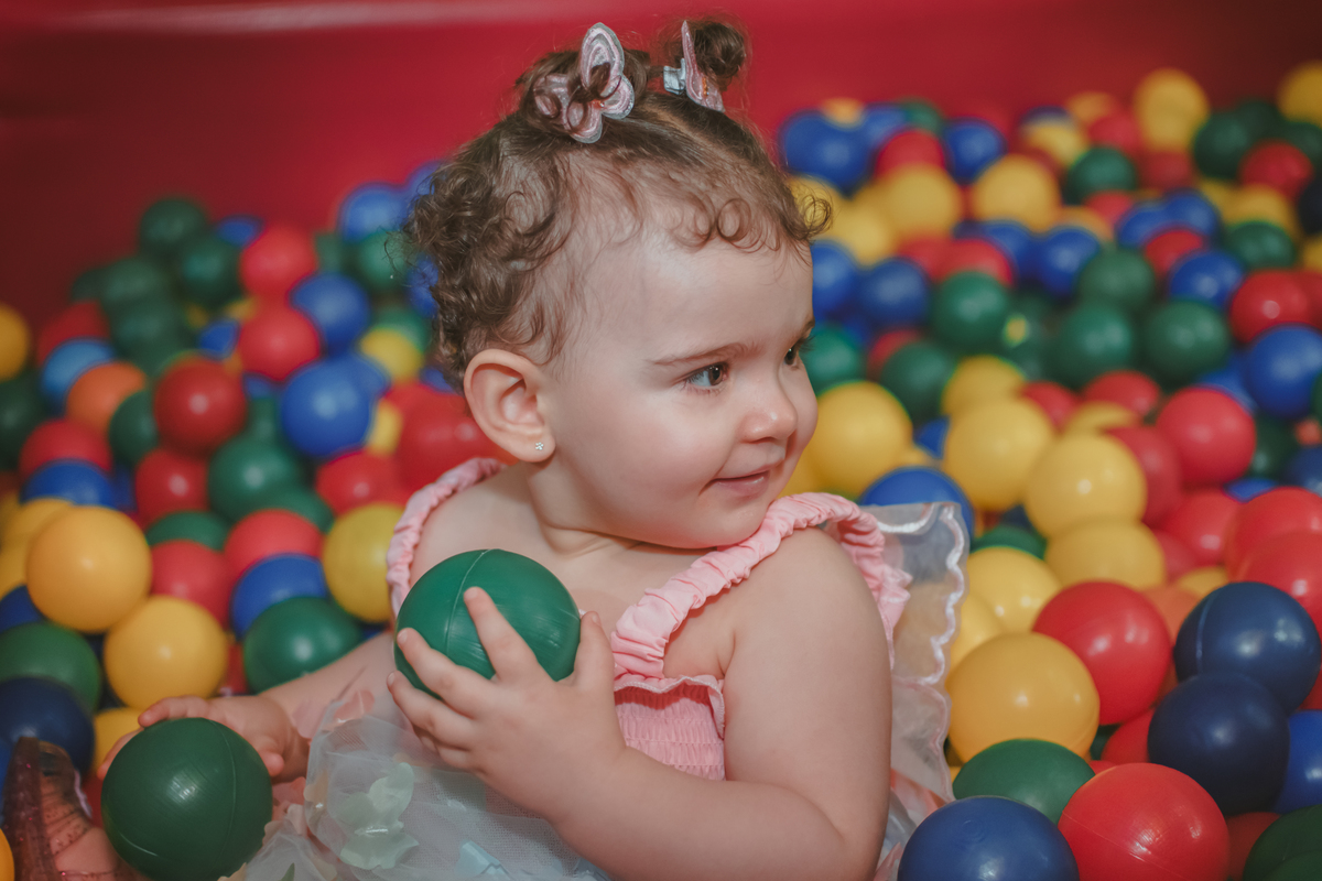 Uma bebê de um ano brincando na piscina de bolinhas durante sua festa de aniversário de 1 anoem Santo André.