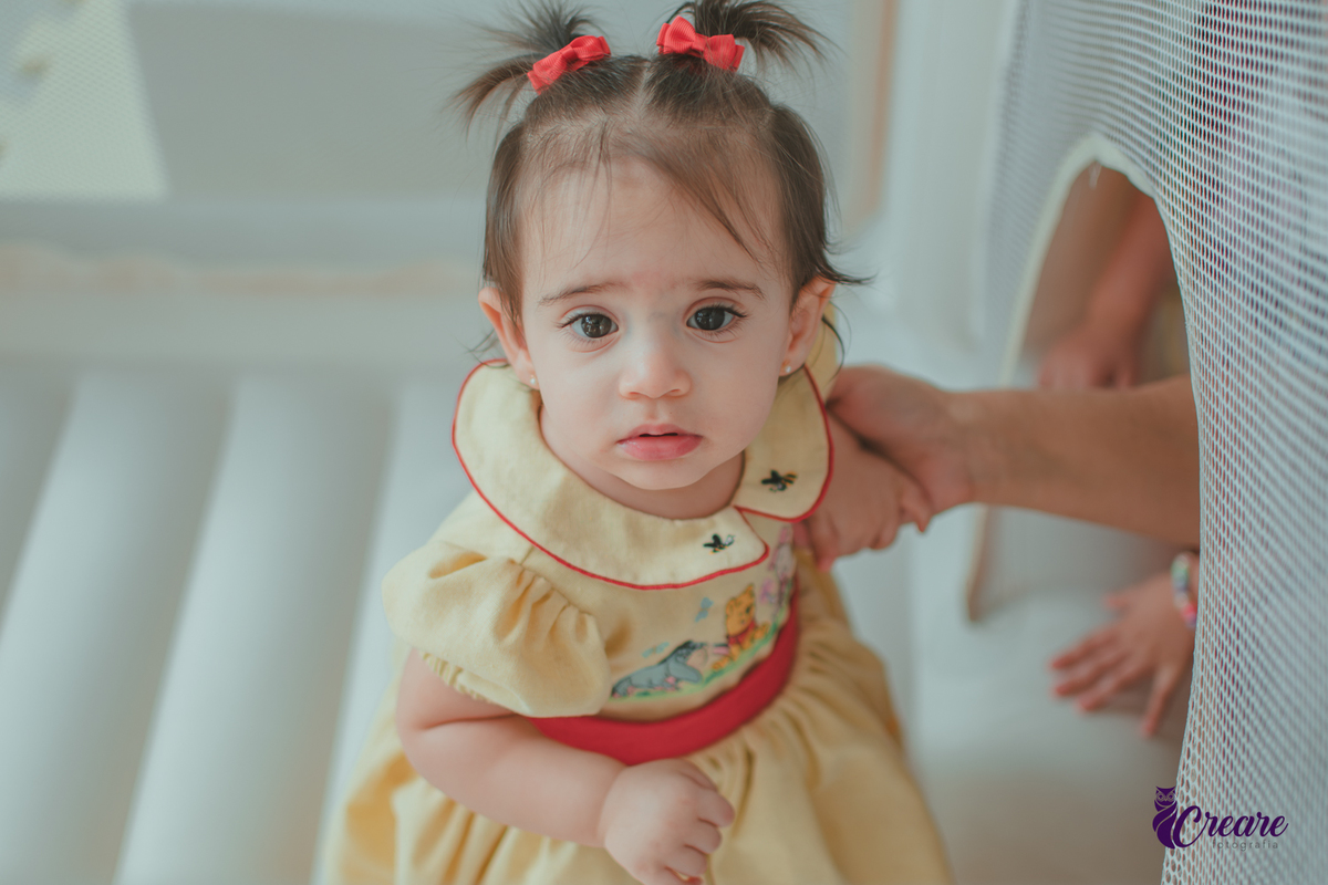 Uma bebê brincando no brinquedo inflável durante sua festa de aniversário de 1 ano.