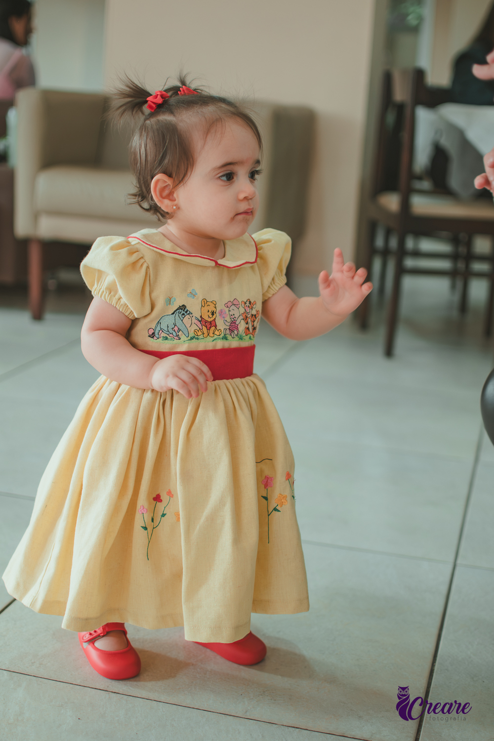 Uma bebê brincando no salão da sua festa de aniversário de 1 ano  feita em casa.