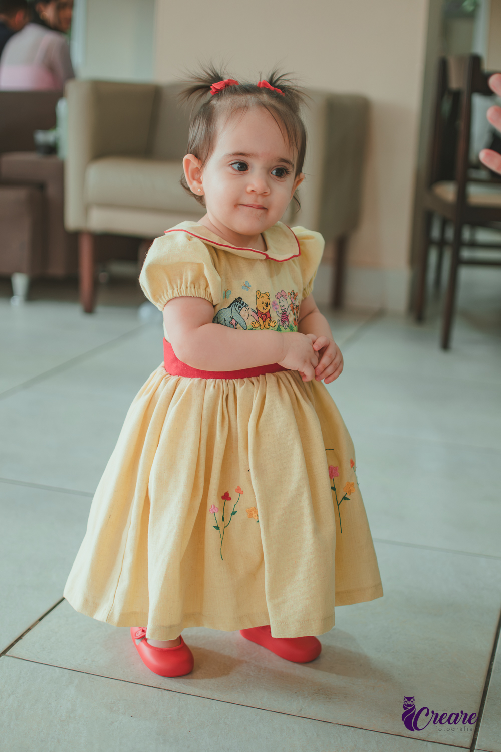 Uma bebê brincando no salão da sua festa de aniversário de 1 ano  feita em casa.