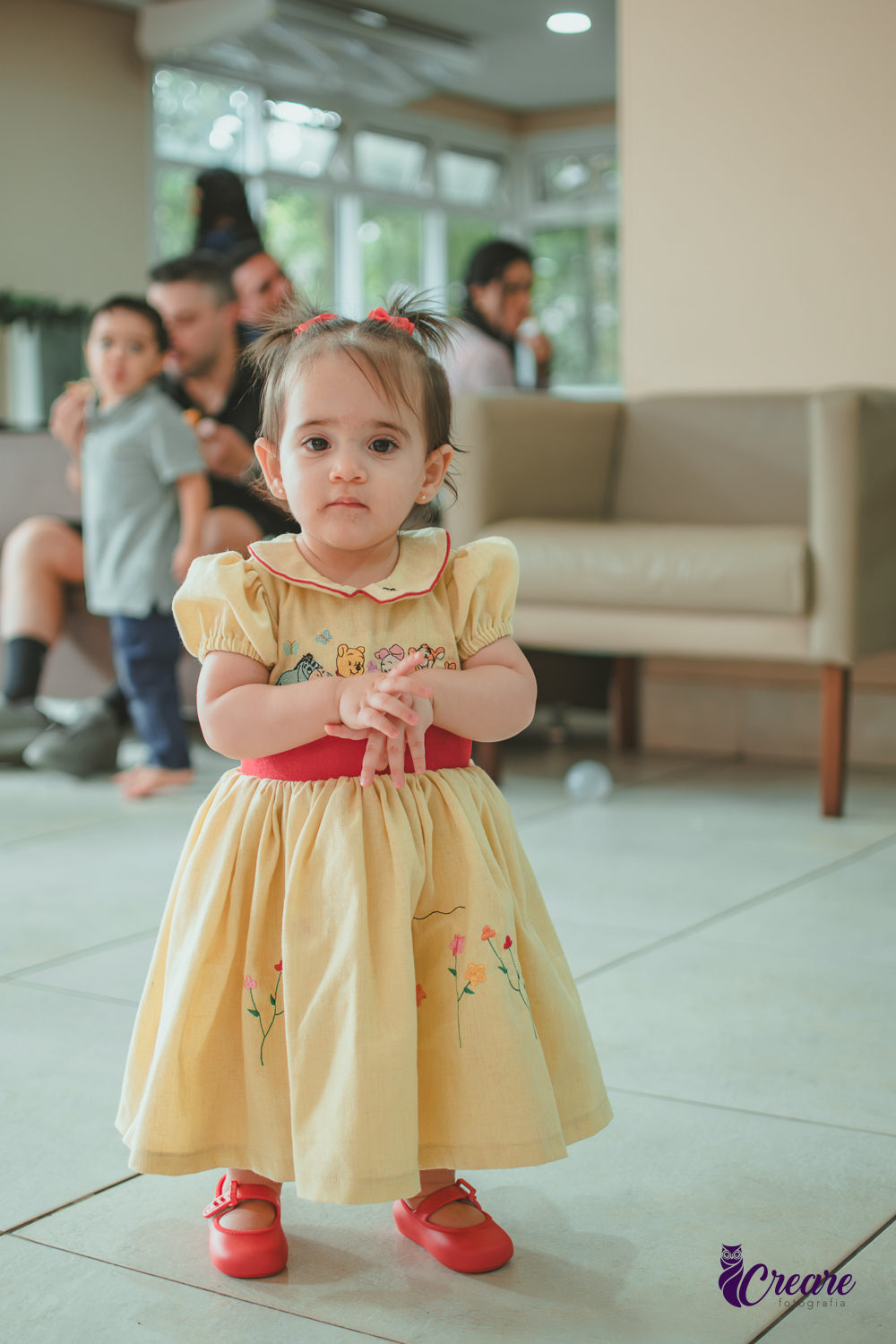 Uma bebê brincando no salão da sua festa de aniversário de 1 ano  feita em casa.
