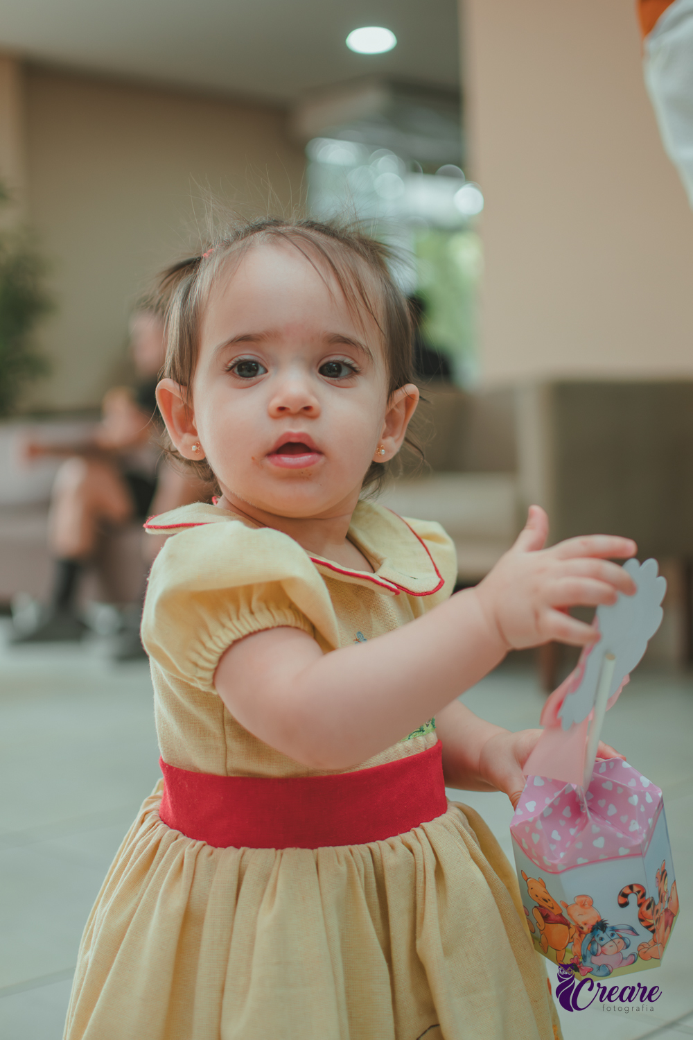 Uma bebê brincando no salão da sua festa de aniversário de 1 ano  feita em casa.