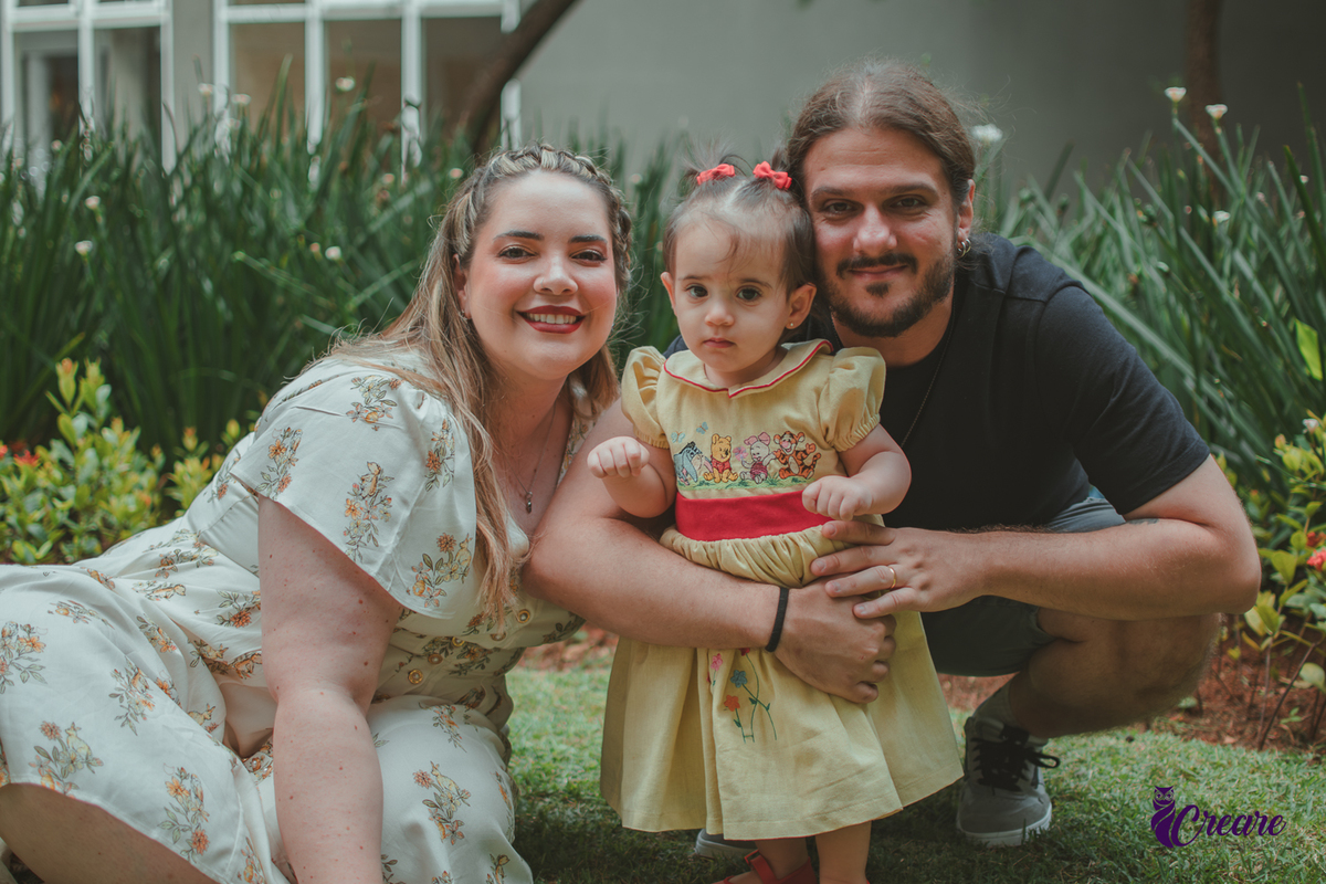 Um casa brincando com bebê de 1 ano, na area externa do prédio, durante sua festa de aniversário em casa.