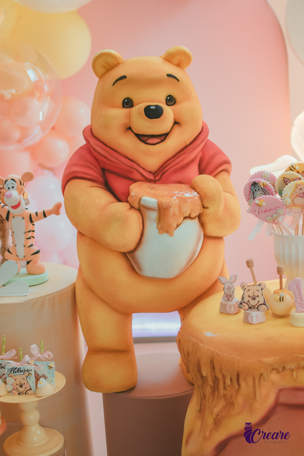Boneco grande do Ursinho Pooh na decoração de uma aniversário de 1 ano em casa.